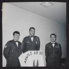 Photograph of three Air Force ROTC cadets with Arnold Air Society flag